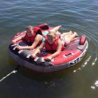 two kids tubing behind boat on Lake Mille Lacs while staying at Red Door Resort